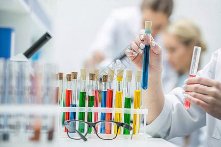 对实验室内带有试剂的女科学家持有测试管和试剂图片素材